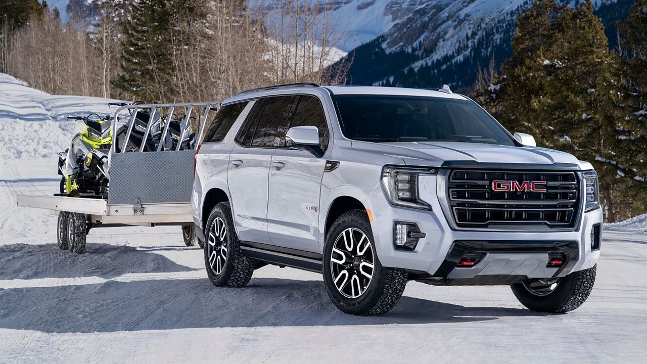 2026 GMC Yukon on snow with a snowmobile trailer